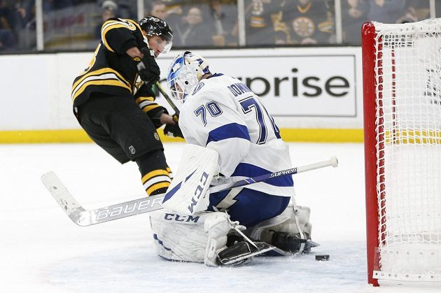 Hvězdný útočník Bostonu Brad Marchand (63) střílí gól do sítě Tampy Bay Lightning. Naštvaný brankář Louis Domingue (70) pak vzteky zlomil hokejku.