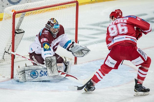 Brankář Sparty Tomáš Pöpperle při zákroku proti třineckému útočníkovi Marku Růžičkovi.