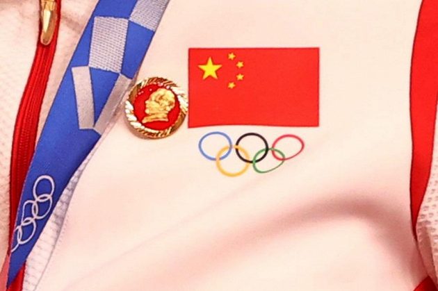 Odznáček s podobiznou někdejšího komunistického vůdce Mao Ce-tunga na oblečení jedné z Číňanek.