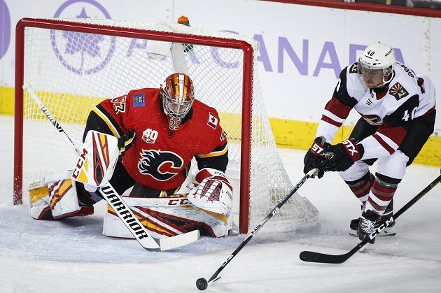 Hokjista Arizony Coyotes Michael Grabner se zkouší prosadit před brankou Davida Ritticha z Calgary.