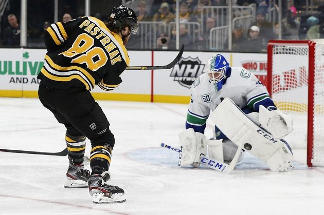 Brankář Vancouveru Canucks Jacob Markstrom zastavuje ránu českého útočníka Davida Pastrňáka z Bostonu v utkání NHL.