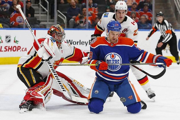 Brankář Calgary Flames David Rittich (33) zasahuje v utkání s Edmontonem, v šanci byl útočník Oilers Kyle Brodziak (28).
