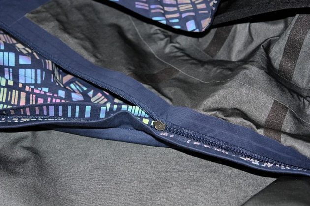Běžecká bunda Nike HyperShield Flash: Zip kapuce je ukryt mezi dva přehyby látky.