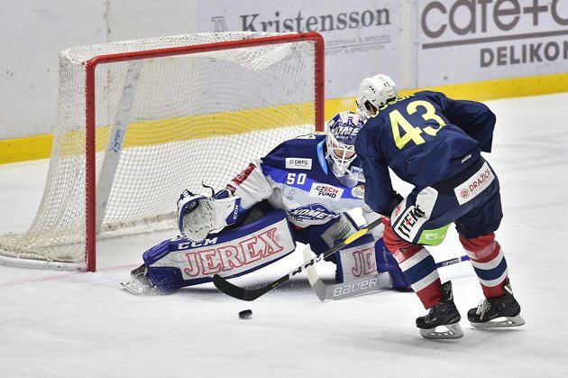 Brankář Brna Karel Vejmelka v akci, na jeho branku najíždí v utkání hokejové extraligy Antonín Dušek z Pardubic.