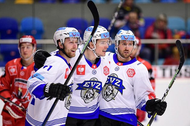 Hokejisté Zugu (zleva) Dario Meyer, Dario Simion a David Mcintyre oslavují gól v utkání Ligy mistrů v Hradci Králové.