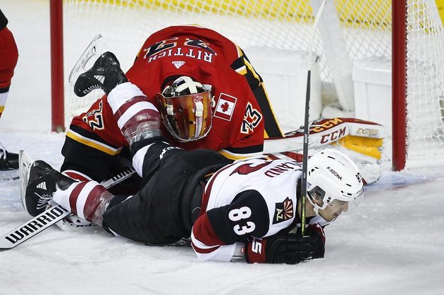 Hokejista Arizony Coyotes Conor Garland přistál na ledě a narazil do českého gólmana Davida Ritticha v brance Calgary Flames.
