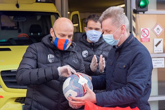 Trenér fotbalové Plzně Adrian Guľa (vpravo) podepisuje míč během poděkování Viktorie plzeňským záchranářům.