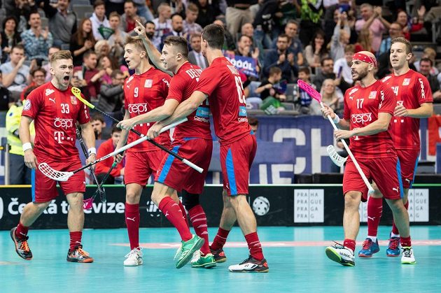 Adam Delong oslavuje se spoluhráči gól na 1:1 během utkání v základní skupině Mistrovství světa ve florbale
