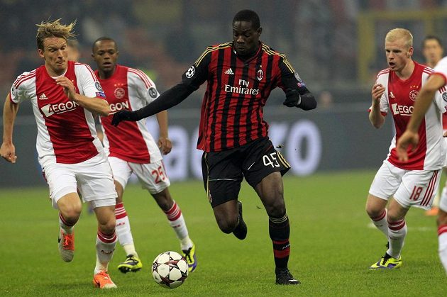 Útočník AC Milán Mario Balotelli (uprostřed) si kryje míč před Christianem Poulsenem (vlevo) z Ajaxu.