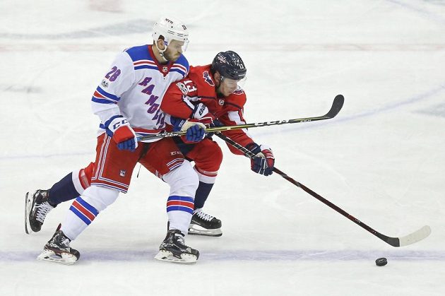 Ćeský útočník Washingtonu Jakub Vrána (v červeném) bojuje o puk s útočníkem NY Rangers Pauley Careyem.