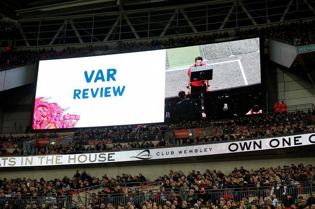 Obrázek známý třeba i z pražského derby... Světelná tabule ve Wembley dává divákům najevo, že rozhodčí studuje video.