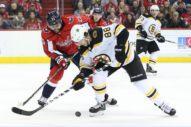Český útočník David Pastrňák z Bostonu se snaží v utkání NHL uniknout soupeři z Washingtonu, kterým byl Devante Smith-Pelly.