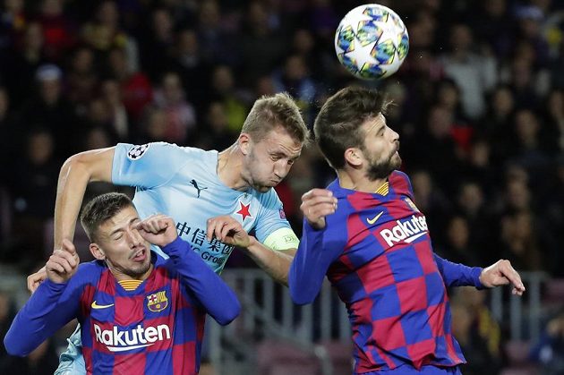 Kapitán Slavie Tomáš Souček v hlavičkovém souboji s Gerardem Piquém (vpravo) z Barcelony.