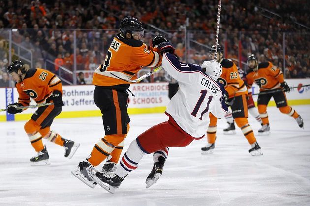 Důrazný bek Radko Gudas (3) z Philadelphie v souboji s Mattem Calvertem (11) z Columbusu v zápase NHL.