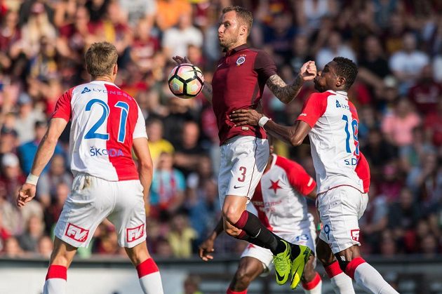 Michal Kadlec ze Sparty Praha (uprostřed) zpracovává míč před Simonem Delim ze Slavie (vpravo). Vlevo přihlíží Milan Škoda.