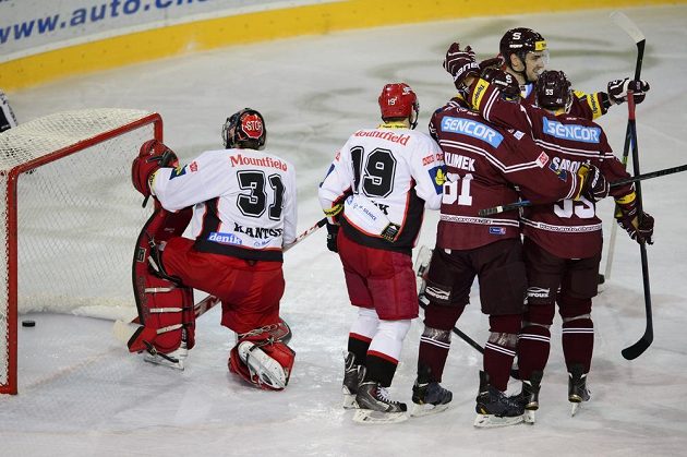 Sparťanští hokejisté se radují ze vstřelení gólu proti Hradci Králové. Vlevo zklamaný brankář Východočechů Pavel Kantor a obránce Martin Pláněk.