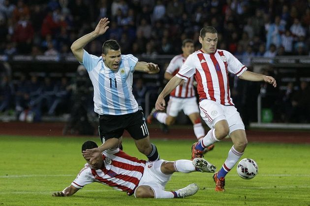 Útočník Sergio Agüero padá v souboji s paraguayskou obranou v zápase na mistrovství Jižní Ameriky.