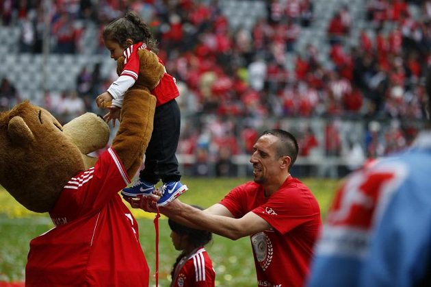 Fotbalista Bayernu Mnichov Franck Ribéry předává maskotovi Bernimu svou dceru.