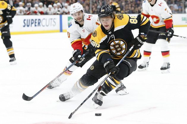 Český útočník David Pastrňák z týmu Boston Bruins ujíždí soupeři Dereku Ryanovi z Calgary v utkání NHL.