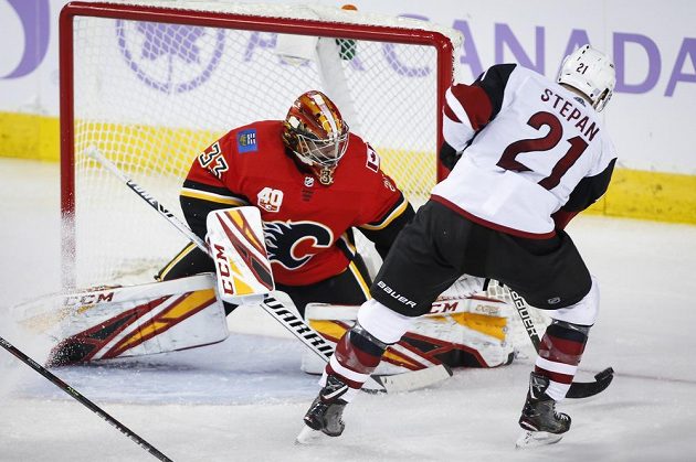 Hokejista Arizony Coyotes Derek Stepan zkouší vyzrát na Davida Ritticha v brance Calgary Flames.