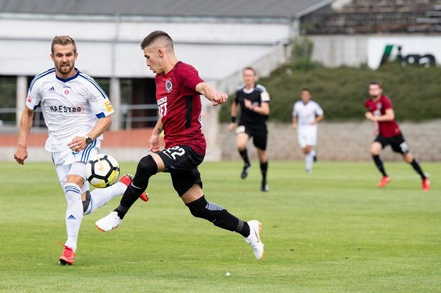 Fotbalista Sparty Srdjan Plavšič odehrává míč před Dominikem Kuncou z Ružomberku během přípravného utkání.