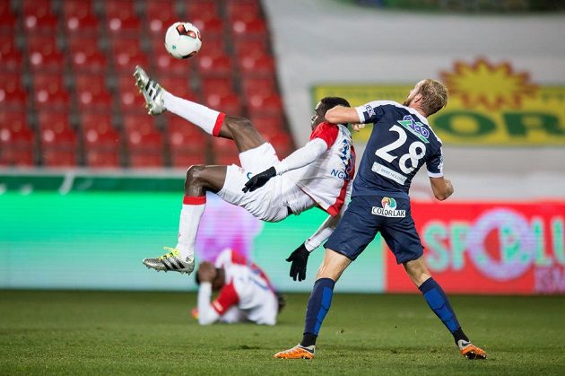 Michael Ngadeu ze Slavie Praha (vlevo) se pokouší o nůžky. Vpravo Vlastimil Daníček ze Slovácka.