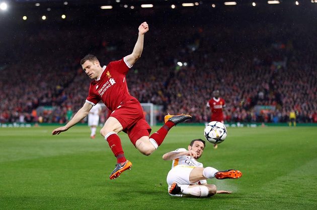 Alessandro Florenzi (na trávníku) z AS Řím zastavuje Jamese Milnera z Liverpoolu.