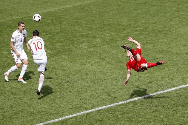 Švýcar Xherdan Shaqiri (vpravo) obstřeluje polské bloky a střílí vyrovnávací gól.