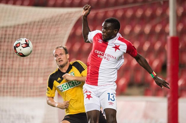 Michael Ngadeu ze Slavie Praha hlavičkuje míč před Pavlem Košťálem z Karviné.