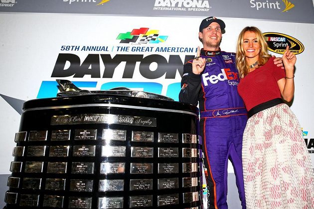 Denny Hamlin (11) pózuje s Harley J. Earl Trophy a přítelkyní Jordan Fishovou po triumfu v Daytoně.