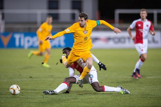 Michael Ngadeu ze Slavie Praha (na zemi) se snaží odebrat míč Markovi Hanousekovi z Dukly Praha.