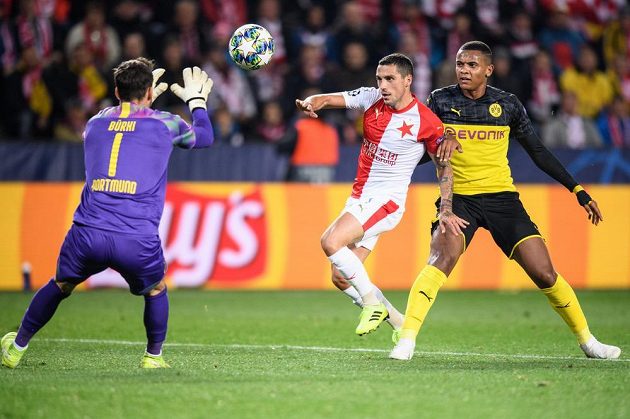 Brankář Dortmundu Roman Bürki se chstá chytit míč, dobíhá Nicolae Stanciu ze Slavie a Manuel Akanji z Dortmundu během utkání základní skupiny Ligy mistrů v Praze.