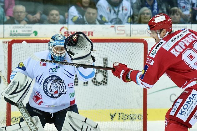 Tomáš Kopecký z Třince se snaží tečovat puk před brankářem Liberce Janem Lašákem.
