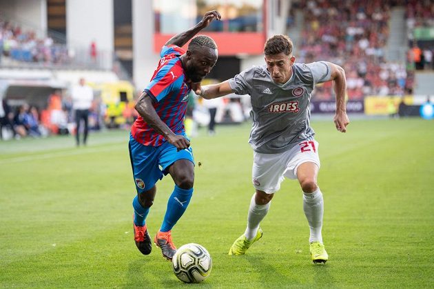 Joel Kayamba z Viktorie Plzeň a Konstantinos Tsimikas z Olympiakosu v akci během utkání 2. předkola Ligy mistrů.