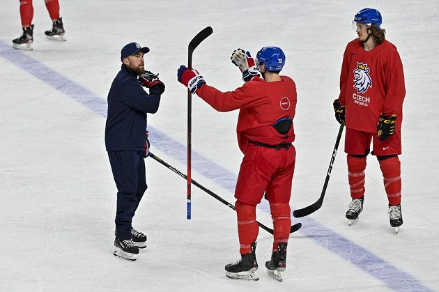 Coach Filip Pešán in a discussion with forward Filip Chytil.  On the right, defender Libor Šulák watches.