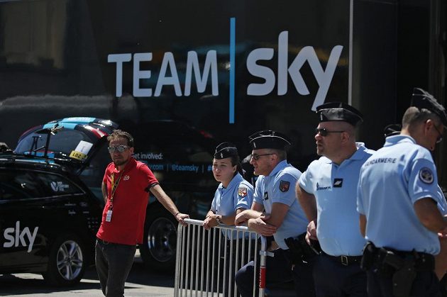 Policisté během časovky na Tour de France poblíž autobusu týmu Sky, za který jezdí lídr závodu Brit Chris Froome.