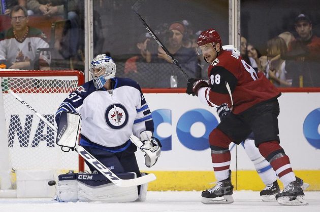 Gólman Winnipegu Connor Hellebuyck (37) je překonán po střele Radima Vrbaty (není na snímku), raduje se další hráč Arizony Jamie McGinn (88)