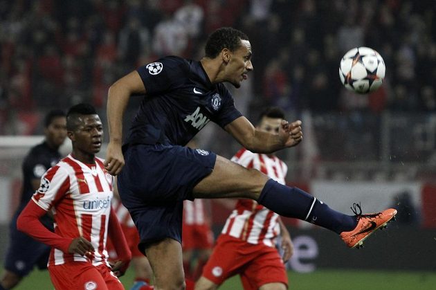 Rio Ferdinand z Manchesteru United v utkání Ligy mistrů odkopává míč, vlevo přihlíží Michael Olaitan z Olympiakosu Pireus.