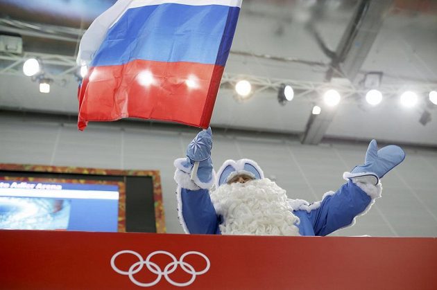 Fanoušek se rozehřívá před startem olympijského závodu rychlobruslařů na 5000 metrů.