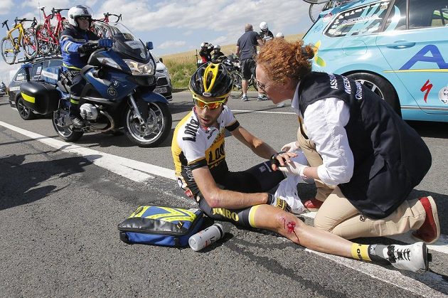 Lékařka ošetřuje zraněného nizozemského cyklistu Laurensa ten Dama po hromadném pádu na Tour.