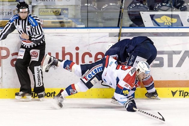 Pardubický útočník Dmitrij Moňa (vpředu) a chomutovský obránce Adam Jánošík v utkání 42. kola hokejové Tipsport extraligy.
