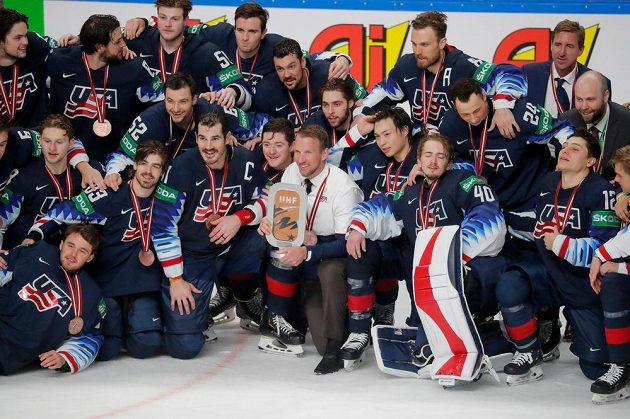 Američtí hokejisté pózují s trofejí pro bronzové medailisty rižského šampionátu.