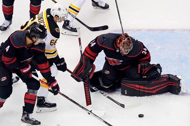 Centr Bostonu Bruins Jack Studnicka (68) před brankou Caroliny Hurricanes, kterou střežil český gólman Petr Mrázek.