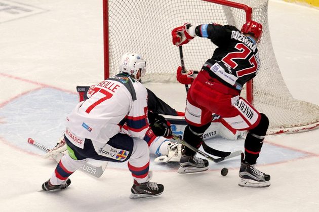 Brankář Ondřej Kacetl z Pardubic vyráží střelu třineckého Martina Růžičky ve čtvrtfinále play off hokejové extraligy. Vlevo přihlíží situaci Sacha Treille z Pardubic.