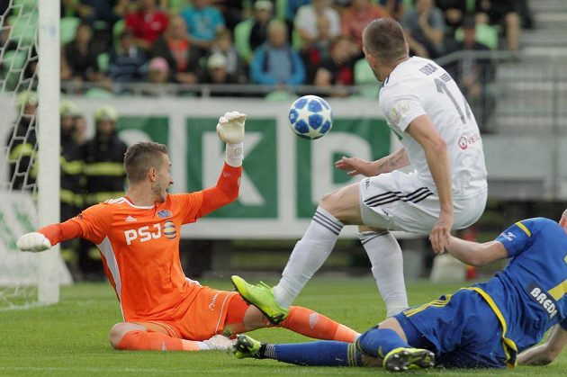 Střela, ze které padla první branka barážového zápasu o účast v první fotbalové lize. Zleva brankář Jihlavy Luděk Vejmola, Dávid Guba z Karviné a Petr Breda z Jihlavy.