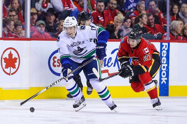 Radim Vrbata (vlevo) při své premiéře v dresu Vancouveru v NHL našlápl a uniká Masonu Raymondovi z Calgary.