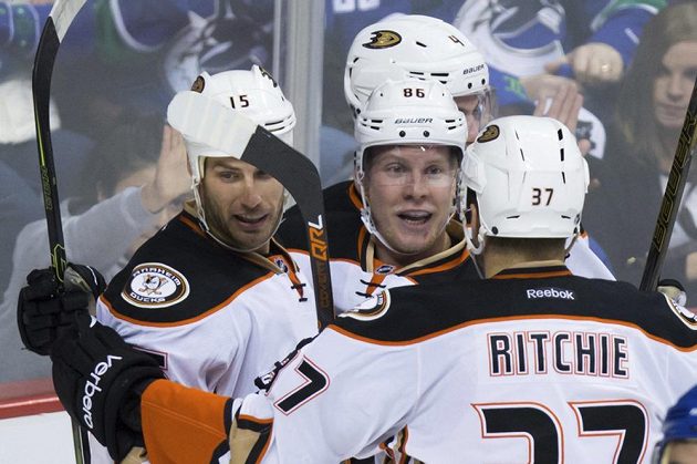 Útočník Anaheimu Ducks Ondřej Kaše (uprostřed) přijímá gratulace od Ryana Getzlafa (vlevo) a Nicka Ritchieho po premiérové trefě v NHL ve Vancouveru.