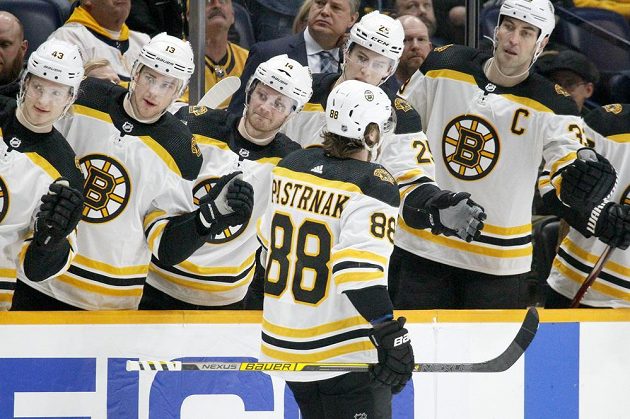 Český útočník David Pastrňák slaví se spoluhráči z týmu Boston Bruins gól vstřelený v utkání NHL.