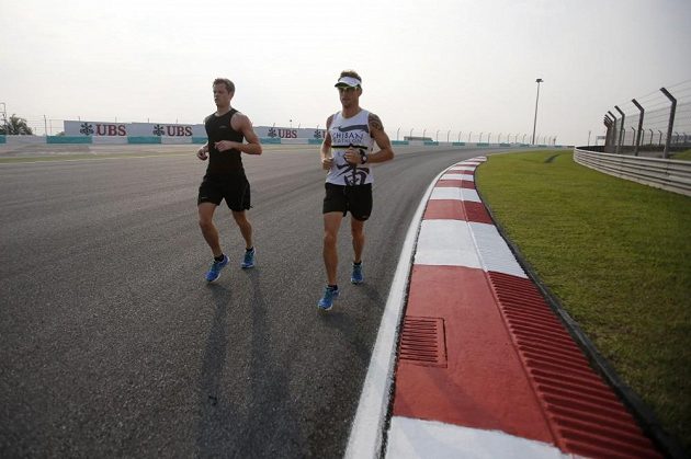 Milovník triatlonu Jenson Button (vpravo) si nenechal ujít možnost proběhnout se po okruhu v Sepangu.