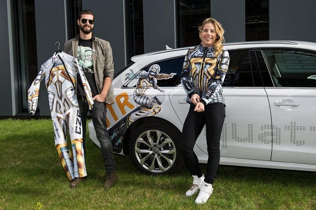 Snowboardistka a lyžařka Ester Ledecká pózuje v nové kombinéze pro nadcházející sezónu. Vlevo přihlíží její bratr Jonáš.